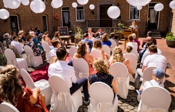 Binnenplaats van Hoeve Vernelsberg met lange tafel en parasols